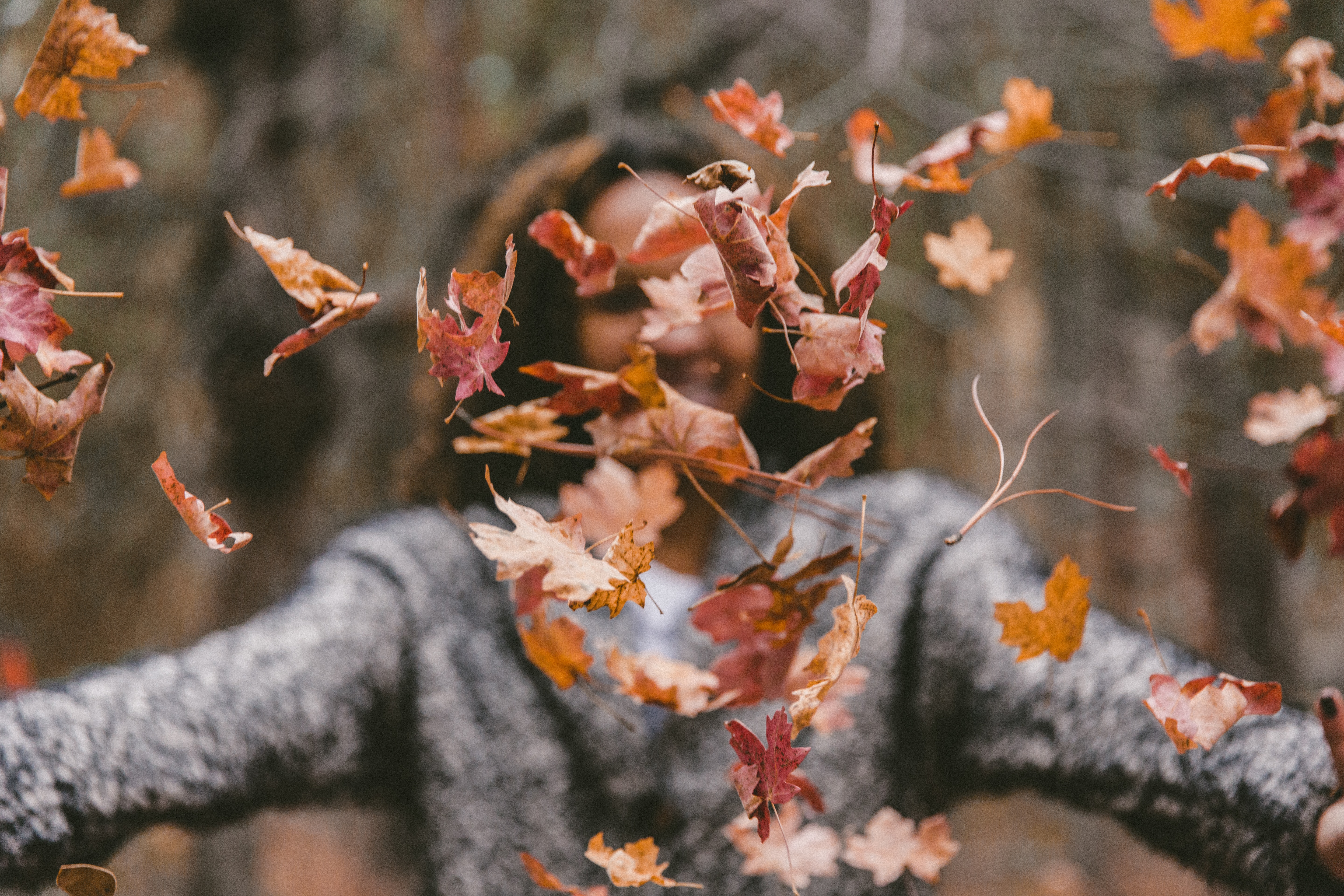 Woman tossing Fall leaves