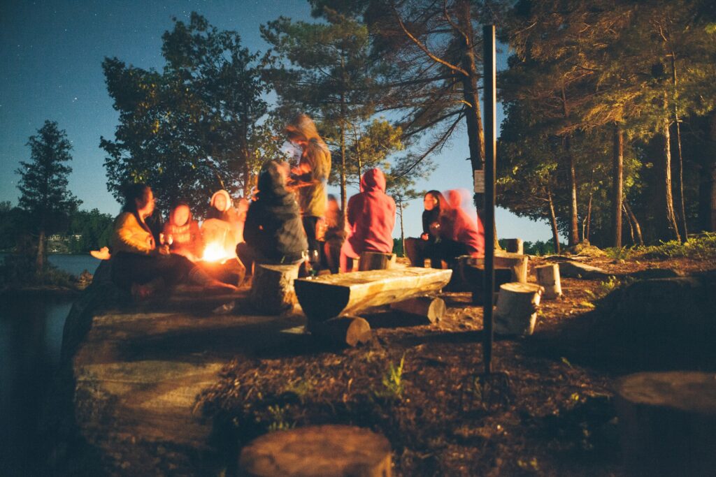 photo- friends gathered around a campfire at dusk